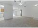 Open living room with carpet, a ceiling fan, and a view into the dining area and kitchen at 13875 Se 97Th Ave, Summerfield, FL 34491
