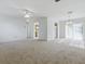 Spacious living room with carpet, a ceiling fan, and sliding glass doors leading to the outside at 13875 Se 97Th Ave, Summerfield, FL 34491