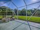 Enclosed patio with view of the green backyard, stone table, and bench at 13875 Se 97Th Ave, Summerfield, FL 34491