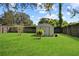 A well-maintained backyard featuring a shed and lush green grass at 1416 Abigail Dr, Apopka, FL 32703