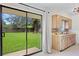 Bright kitchen with sliding glass doors to the backyard, wood cabinets and white appliances at 1416 Abigail Dr, Apopka, FL 32703