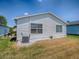 Backyard view of a single-story house with white siding, a well-maintained lawn, and an AC unit at 1722 Moreno Pl, The Villages, FL 32159