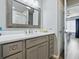 Bathroom vanity with neutral gray wood cabinets, white counters, and a large framed mirror above a basin sink at 1722 Moreno Pl, The Villages, FL 32159