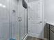 Walk-in shower with tiled walls, a blue mat, glass door, and a white door with a rack at 1722 Moreno Pl, The Villages, FL 32159