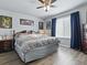 Bedroom with hardwood floors, ceiling fan, artwork, and a comfortable bed at 1722 Moreno Pl, The Villages, FL 32159