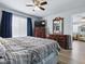 Comfortable bedroom with ceiling fan, hard wood floors, and dark blue curtains at 1722 Moreno Pl, The Villages, FL 32159