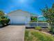 Charming single-story home with a white picket fence, well-manicured lawn, and attached garage at 1722 Moreno Pl, The Villages, FL 32159