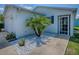 Property featuring an inviting entryway with clean white stone accents and palm trees at 1722 Moreno Pl, The Villages, FL 32159