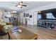 Comfortable living room featuring wood flooring, a ceiling fan, and an entertainment center at 1722 Moreno Pl, The Villages, FL 32159