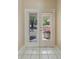 Entryway view of the exterior through glass paned double doors and a white-tiled floor at 1725 14Th St, Orange City, FL 32763