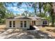 Inviting single-story home featuring double doors, a well-manicured lawn, and lush greenery at 1725 14Th St, Orange City, FL 32763