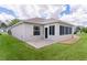 Back exterior view of home with a patio, screened-in lanai and well-manicured lawn at 1813 Caryle Ln, The Villages, FL 32162