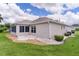 Back exterior view of home with a patio, screened-in lanai and well-manicured landscaping at 1813 Caryle Ln, The Villages, FL 32162