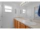 Bright bathroom featuring double sinks with neutral countertops, bright lighting, and ample counter space at 1813 Caryle Ln, The Villages, FL 32162
