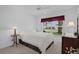 Bright bedroom with a ceiling fan, a comfortable bed, and a view from the window at 1813 Caryle Ln, The Villages, FL 32162