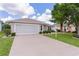 Charming single-story home with a well-maintained lawn and a two-car garage at 1813 Caryle Ln, The Villages, FL 32162