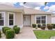 Inviting exterior showcasing a well-kept lawn, front door, manicured bushes, and natural light at 1813 Caryle Ln, The Villages, FL 32162