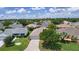 Charming single-story home featuring a well-manicured lawn, mature trees, and a clean, inviting facade at 1813 Caryle Ln, The Villages, FL 32162