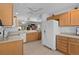 Spacious kitchen featuring wooden cabinets, white appliances, and tile floors at 1813 Caryle Ln, The Villages, FL 32162