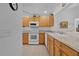 Bright kitchen features wooden cabinets, white appliances, and tile flooring at 1813 Caryle Ln, The Villages, FL 32162