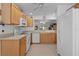 Bright kitchen features wooden cabinets, white appliances, and tile flooring at 1813 Caryle Ln, The Villages, FL 32162