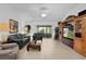 Bright living room featuring tile flooring, sliding glass doors, comfortable seating, and built-in shelving at 1813 Caryle Ln, The Villages, FL 32162