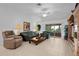 Bright living room featuring tile flooring, sliding glass doors, comfortable seating, and built-in shelving at 1813 Caryle Ln, The Villages, FL 32162