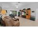 Bright living room featuring tile flooring, sliding glass doors, comfortable seating, and built-in shelving at 1813 Caryle Ln, The Villages, FL 32162