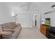 Spacious living room featuring soft carpeting, a comfy couch, ceiling fan and plenty of closet space at 1813 Caryle Ln, The Villages, FL 32162