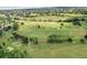 Sweeping aerial view of the golf course community featuring lush landscaping, mature trees, and perfectly manicured grounds at 1930 Farmington Ct, Clermont, FL 34711