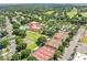 Community aerial featuring the pool, clubhouse, tennis and bocce ball courts and many mature trees at 1930 Farmington Ct, Clermont, FL 34711