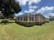 The backyard features a screened-in lanai and well-maintained landscaping on the golf course at 1930 Farmington Ct, Clermont, FL 34711