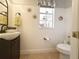 Elegant powder room with white wainscoting, decorative mirror, and a stylish pedestal sink at 1930 Farmington Ct, Clermont, FL 34711