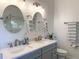 Bathroom featuring a double vanity with modern fixtures and round mirrors, offering a bright and functional space at 1930 Farmington Ct, Clermont, FL 34711