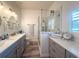 Bright bathroom featuring a double vanity, frameless shower, and neutral decor for a clean, modern aesthetic at 1930 Farmington Ct, Clermont, FL 34711