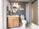 Charming bathroom features a wooden vanity, oval mirror, and a shower with a decorative blue patterned curtain at 1930 Farmington Ct, Clermont, FL 34711