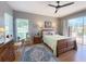 Comfortable bedroom with wood floors, ceiling fan, dresser, and sliding glass door to the patio at 1930 Farmington Ct, Clermont, FL 34711