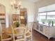 Inviting dining room features a chandelier, hardwood floors, and natural light from a nearby window at 1930 Farmington Ct, Clermont, FL 34711