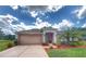 Charming single-story home boasts a well-manicured lawn, tan color scheme, and inviting front entry at 1930 Farmington Ct, Clermont, FL 34711