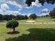 Scenic golf course view features lush green fairways, mature trees, and a sand trap at 1930 Farmington Ct, Clermont, FL 34711