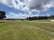 Scenic view of the lush green golf course on a sunny day with scattered trees at 1930 Farmington Ct, Clermont, FL 34711