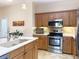 Well-equipped kitchen featuring stainless steel appliances and wood cabinets with tiled backsplash at 1930 Farmington Ct, Clermont, FL 34711