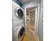 A bright laundry room with a stackable washer and dryer and frosted glass door at 1930 Farmington Ct, Clermont, FL 34711