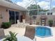 Screened-in patio with a small pool, comfortable seating, and potted plants, perfect for relaxing outdoors at 1930 Farmington Ct, Clermont, FL 34711