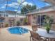 Screened-in patio with a small pool, comfortable seating, and potted plants, creating a relaxing outdoor retreat at 1930 Farmington Ct, Clermont, FL 34711