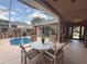 Screened-in patio with a small pool, comfortable seating, and potted plants, perfect for relaxing outdoors at 1930 Farmington Ct, Clermont, FL 34711