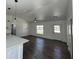 Open-concept living room featuring hardwood floors, ceiling fan, and natural light at 2 Pine Terrace Way, Ocala, FL 34472