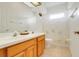 Well-lit bathroom featuring a double vanity and bathtub-shower combo with a decorative shower curtain at 21226 Royal St Georges Ln, Leesburg, FL 34748