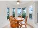 Cozy dining area with a round wooden table surrounded by large windows at 21226 Royal St Georges Ln, Leesburg, FL 34748