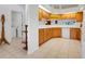 Bright kitchen features wood cabinets, tile flooring, and modern appliances with an adjacent laundry room at 21226 Royal St Georges Ln, Leesburg, FL 34748